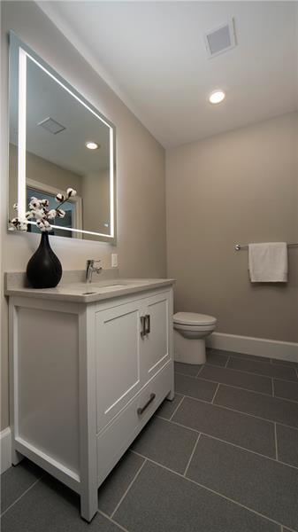 bathroom featuring tile floors, vanity with extensive cabinet space, and toilet