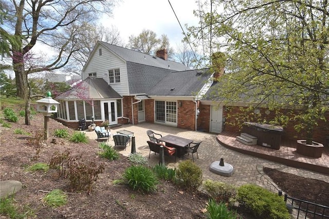 back of property with a fire pit and a patio