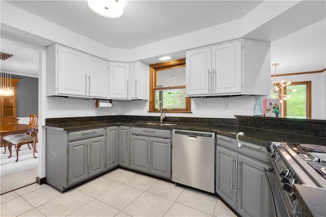 kitchen with gray cabinetry, decorative light fixtures, appliances with stainless steel finishes, and a chandelier