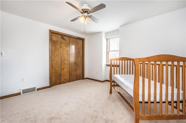 unfurnished bedroom featuring ceiling fan, a closet, and light carpet