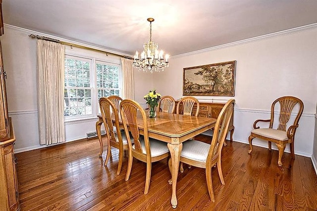 dining room featuring a notable chandelier, dark wood-type flooring, and ornamental molding