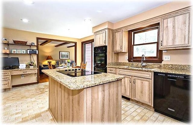 kitchen with light brown cabinetry, a kitchen island, sink, light stone countertops, and black appliances