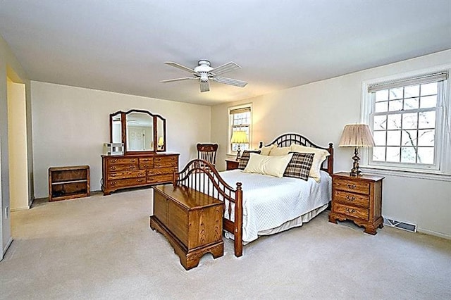 carpeted bedroom featuring ceiling fan and multiple windows