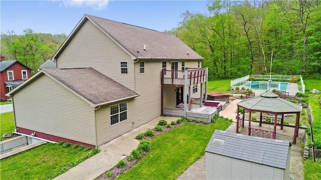 back of house with a pool side deck, a gazebo, and a yard