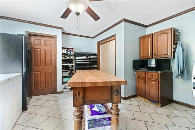 kitchen with black fridge, crown molding, ceiling fan, and light tile flooring