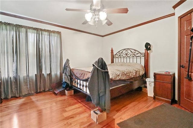 bedroom with light hardwood / wood-style floors, ceiling fan, and ornamental molding