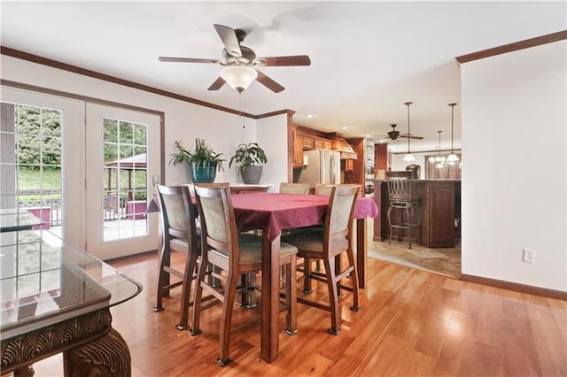 dining space featuring ceiling fan, light wood-type flooring, and ornamental molding