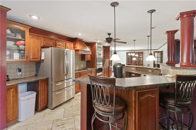 kitchen with a breakfast bar, backsplash, ceiling fan, and stainless steel appliances