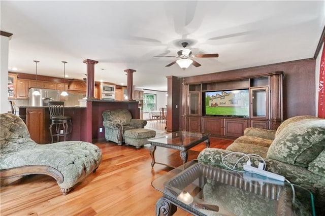 living room with ceiling fan, decorative columns, and light hardwood / wood-style floors