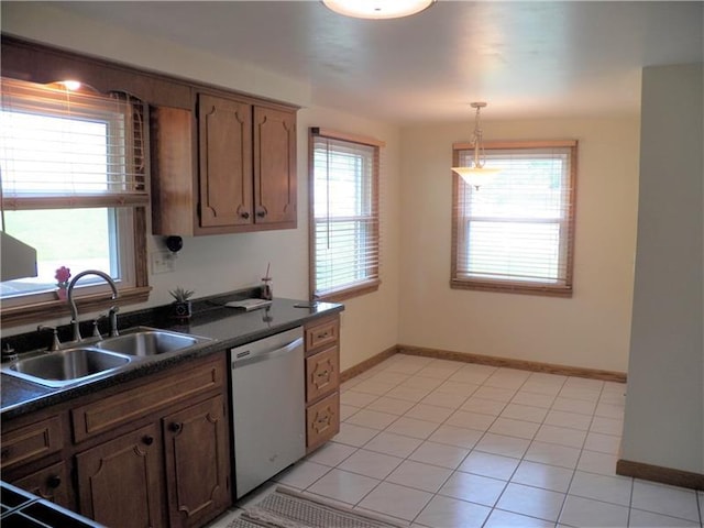 kitchen with decorative light fixtures, a healthy amount of sunlight, light tile floors, and dishwasher