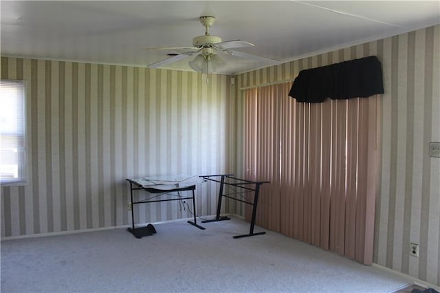 carpeted spare room featuring ceiling fan and a healthy amount of sunlight