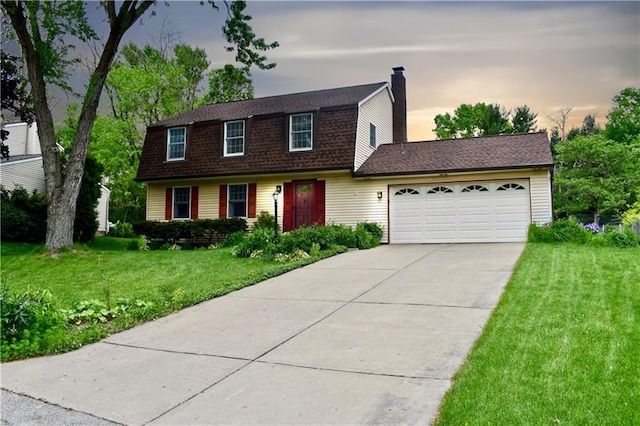 colonial-style house featuring a lawn and a garage