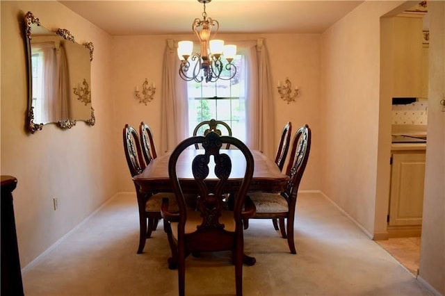 dining area with light carpet and a chandelier