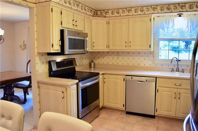 kitchen with light tile floors, appliances with stainless steel finishes, and sink