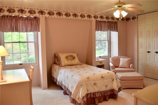 carpeted bedroom featuring ceiling fan and multiple windows