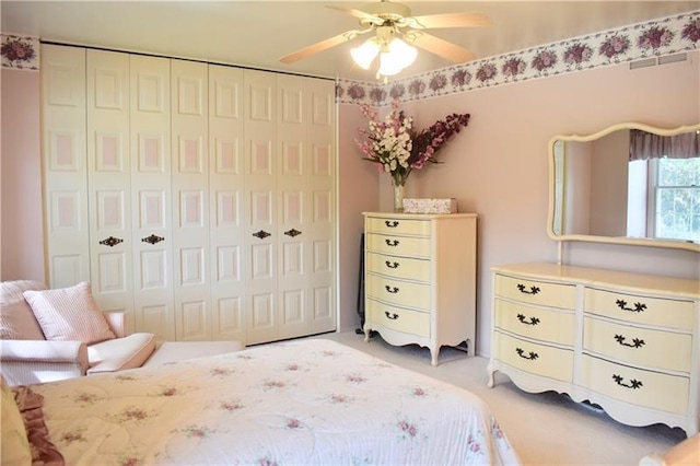 bedroom with ceiling fan, a closet, and light carpet