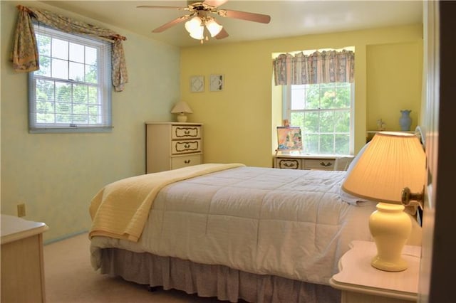 carpeted bedroom featuring ceiling fan and multiple windows