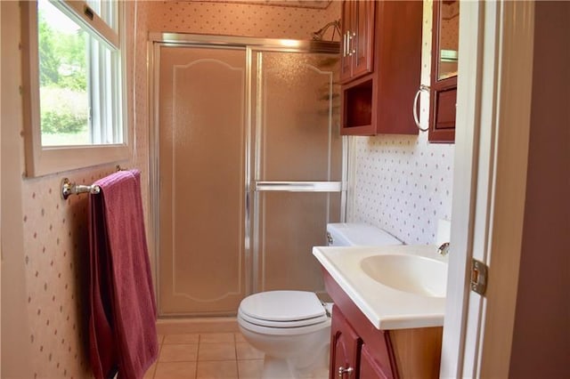 bathroom with vanity, a shower with door, tile flooring, and toilet