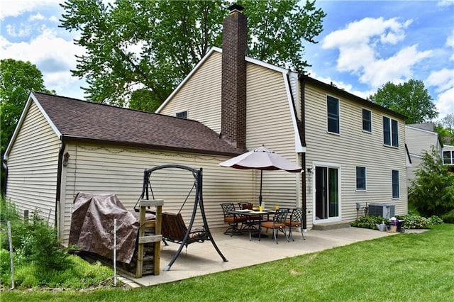 back of house with central AC unit, a yard, and a patio