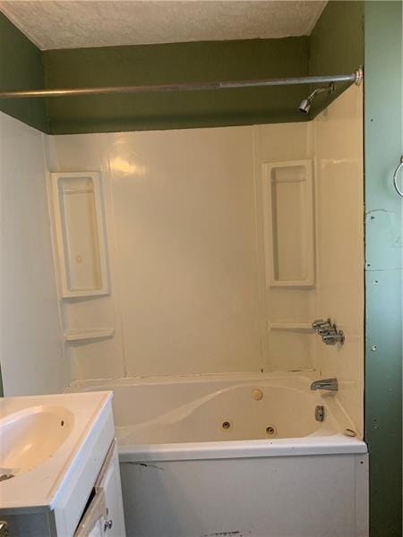 bathroom featuring vanity, a textured ceiling, and shower / bathtub combination