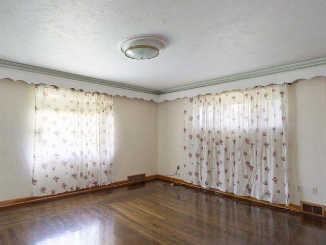 spare room featuring hardwood / wood-style floors and crown molding