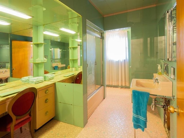 bathroom featuring combined bath / shower with glass door, tile flooring, and sink