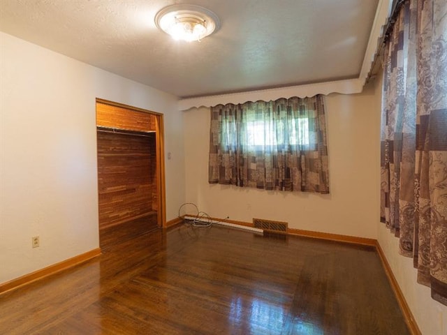 empty room featuring dark wood-type flooring