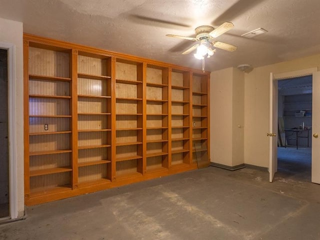 interior space with ceiling fan and a textured ceiling