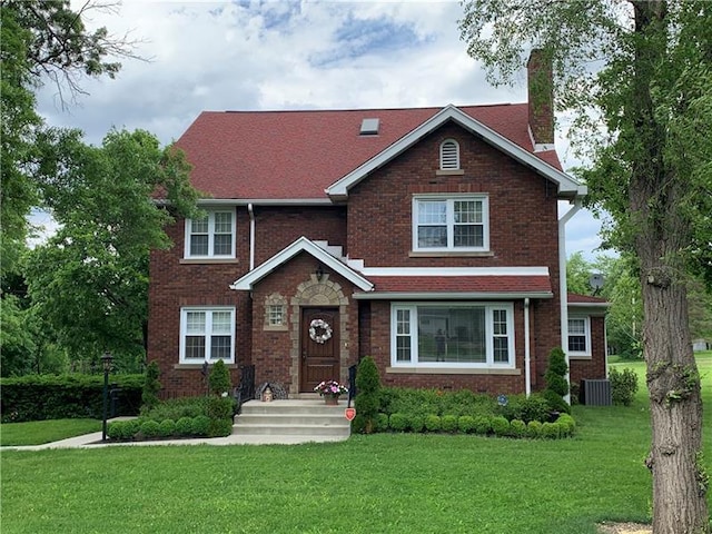 view of front of house featuring central AC and a front yard