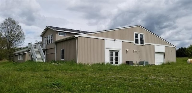 view of side of property featuring central AC unit and a lawn