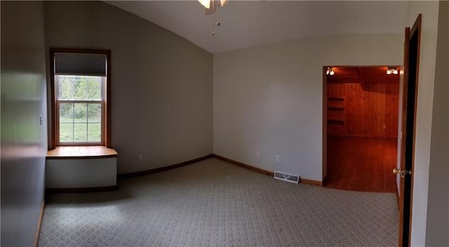 carpeted spare room featuring lofted ceiling and ceiling fan