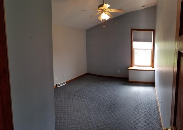 spare room featuring lofted ceiling, dark colored carpet, and ceiling fan