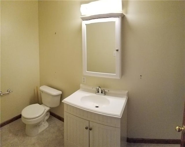 bathroom with tile flooring, toilet, and vanity