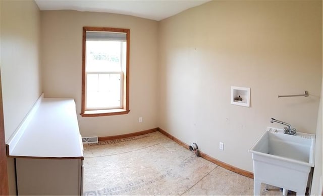 clothes washing area with light tile floors, sink, and hookup for a washing machine