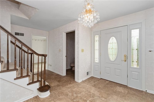 foyer entrance with plenty of natural light, a chandelier, and light tile floors