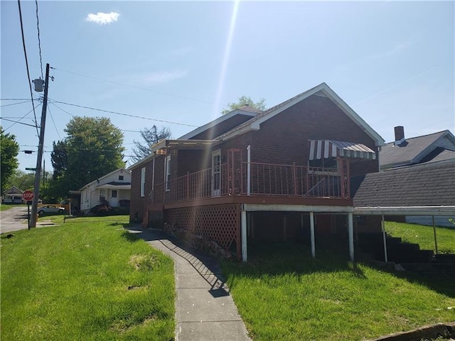 exterior space featuring a wooden deck and a lawn