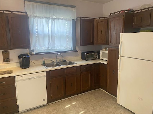 kitchen with light tile flooring, dark brown cabinets, white appliances, and sink