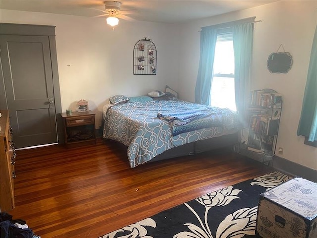 bedroom with dark hardwood / wood-style floors and ceiling fan