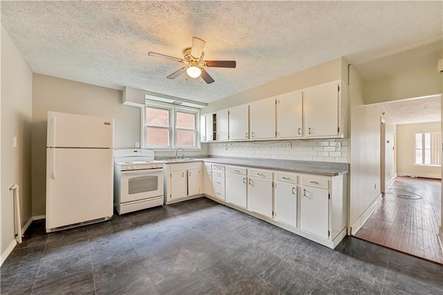 kitchen with dark tile flooring, white appliances, and ceiling fan