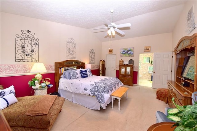 bedroom with ceiling fan, carpet floors, vaulted ceiling, and a textured ceiling