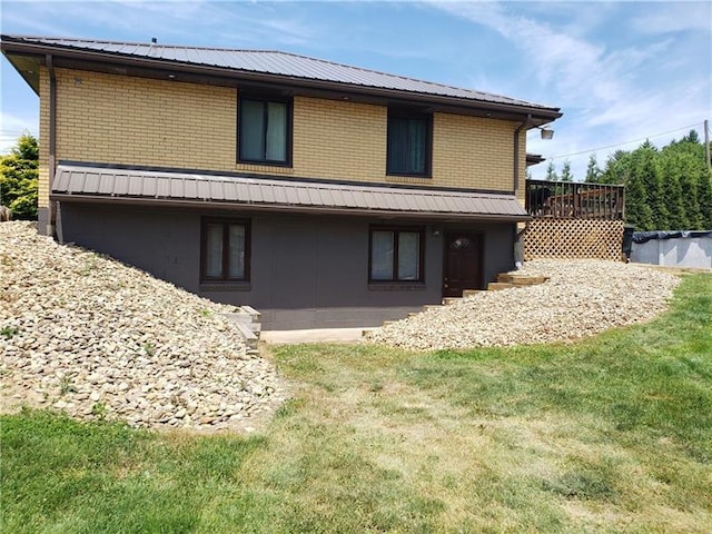 rear view of house with a wooden deck and a yard