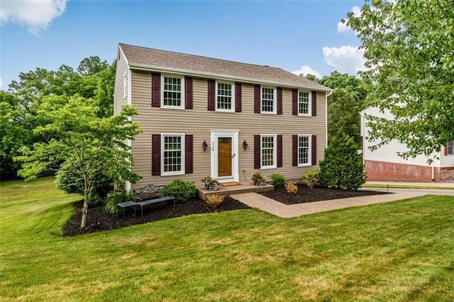 colonial-style house featuring a front yard