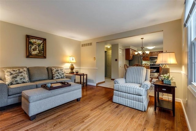 living room with a notable chandelier and light hardwood / wood-style flooring