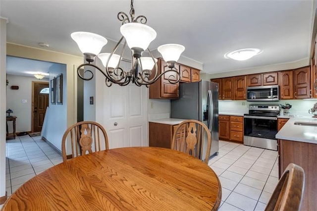 kitchen with an inviting chandelier, light tile floors, stainless steel appliances, sink, and hanging light fixtures