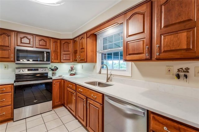 kitchen featuring light tile flooring, ornamental molding, stainless steel appliances, and sink