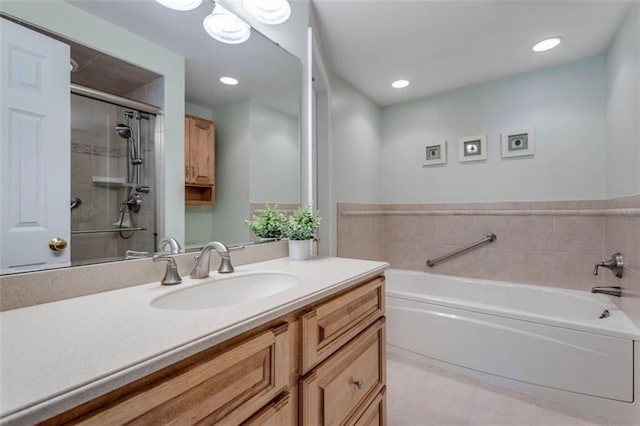 bathroom with oversized vanity, tile floors, and a bath to relax in