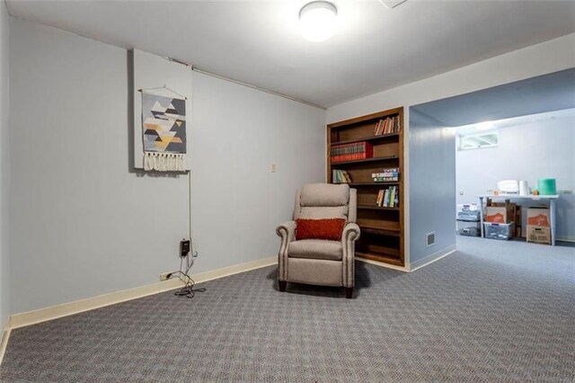 sitting room with built in features and dark colored carpet