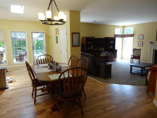 dining room with a chandelier, carpet, and a healthy amount of sunlight