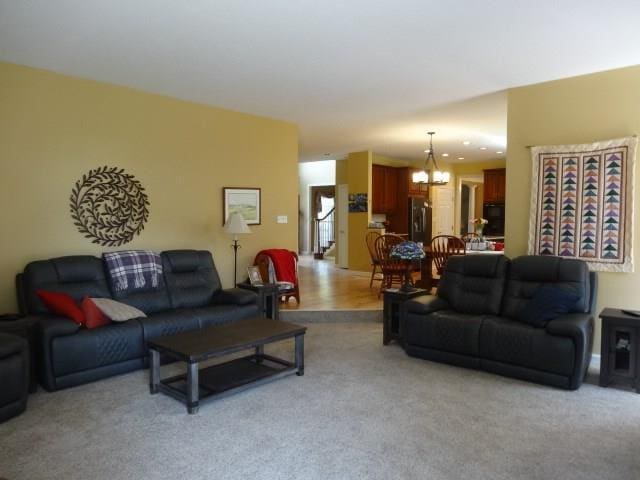 living room with light carpet and an inviting chandelier