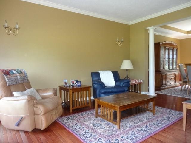 sitting room with wood-type flooring, decorative columns, and ornamental molding